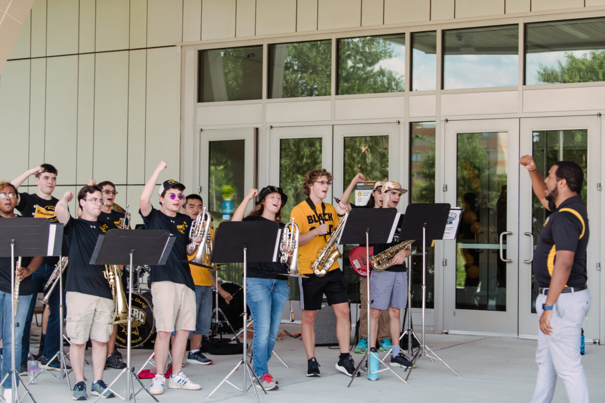 Alum Bentley Corbett-Wilson trumpets the pep band and school spirit